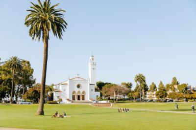 Image of Sacred Heart Chapel with students lounging on Sunken Garden